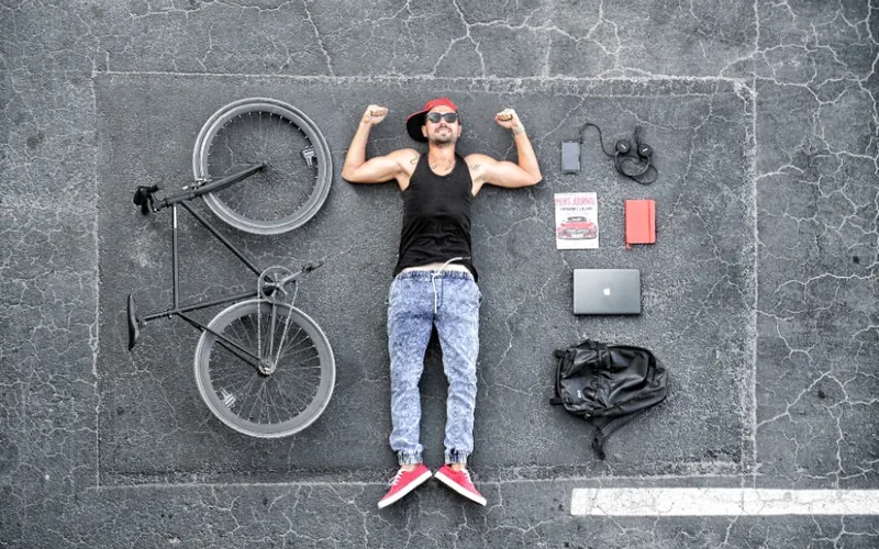 Homem com celular e notebook na cidade